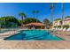 Inviting community pool with deck chairs, palm trees, and a cabana at 2146 W Isabella Ave # 127, Mesa, AZ 85202