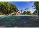 Community tennis court with lush trees and inviting shade at 2146 W Isabella Ave # 127, Mesa, AZ 85202