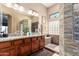 Bathroom featuring double sinks, granite countertops, tile accents, and natural light at 22026 N 44Th Pl, Phoenix, AZ 85050