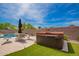 Backyard patio with a hot tub, seating area, and manicured lawn at 22026 N 44Th Pl, Phoenix, AZ 85050