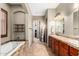 Luxurious bathroom featuring double sink vanity, soaking tub, and walk-in closet for a spa-like experience at 2335 E Allen St, Phoenix, AZ 85042