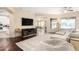 Open concept living room with hardwood floors, TV, and comfortable seating overlooking backyard at 2335 E Allen St, Phoenix, AZ 85042