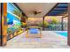 Covered outdoor dining area features a dining table, ceiling fan, and stylish mural for outdoor entertaining near the pool at 2335 E Allen St, Phoenix, AZ 85042