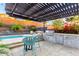Outdoor kitchen featuring stone counters, a built-in grill, and dining area underneath a pergola at 2335 E Allen St, Phoenix, AZ 85042