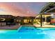 Inviting backyard pool with string lights, covered seating area and outdoor kitchen offers a luxurious outdoor living space at 2335 E Allen St, Phoenix, AZ 85042