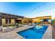 Backyard pool with tanning deck, a modern pergola, and an outdoor dining area featuring lush landscaping at 2335 E Allen St, Phoenix, AZ 85042