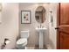 Charming powder room features stylish decor, pedestal sink, and a round mirror for a modern touch at 2335 E Allen St, Phoenix, AZ 85042