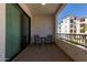 Apartment balcony featuring a small table and chairs, overlooking the complex courtyard at 2511 W Queen Creek Rd # 266, Chandler, AZ 85248
