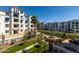 Well-maintained apartment building featuring a pond, manicured landscaping, and palm trees at 2511 W Queen Creek Rd # 266, Chandler, AZ 85248