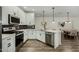 Kitchen featuring white cabinetry, a breakfast bar, stainless steel appliances and wood floors at 2511 W Queen Creek Rd # 266, Chandler, AZ 85248