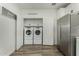 Laundry room with Whirlpool washer and dryer, stainless steel refrigerator, and white cabinets at 2511 W Queen Creek Rd # 266, Chandler, AZ 85248