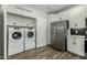 Modern laundry room with washer, dryer, stainless steel refrigerator, and white cabinets at 2511 W Queen Creek Rd # 266, Chandler, AZ 85248