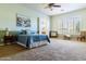 Spacious bedroom with a ceiling fan and a large window, featuring calming wall colors at 26168 W Tina Ln, Buckeye, AZ 85396
