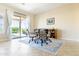Elegant dining area with a glass table, stylish chairs, and access to the backyard through sliding doors at 26168 W Tina Ln, Buckeye, AZ 85396