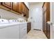 Well-lit laundry room with ample cabinet space above the washer and dryer and neutral-colored flooring at 26168 W Tina Ln, Buckeye, AZ 85396