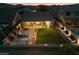 Aerial view of a backyard with a grassy area, patio seating, and string lights at dusk at 27203 N 78Th Ln, Peoria, AZ 85383