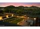 Scenic backyard with lush lawn, cozy patio seating, and mountain views at twilight at 27203 N 78Th Ln, Peoria, AZ 85383
