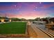 Enjoy a spacious backyard with a lush lawn, cozy firepit area, and desert landscape views at 27203 N 78Th Ln, Peoria, AZ 85383