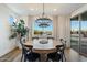 Elegant dining area with a round table, stylish chandelier, and sliding doors to an outdoor patio at 27203 N 78Th Ln, Peoria, AZ 85383
