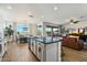 Bright, open kitchen with island seating flows into a dining area and living space with sliding glass doors at 27203 N 78Th Ln, Peoria, AZ 85383