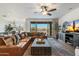 Spacious living room featuring a leather sofa, large windows, and an entertainment center at 27203 N 78Th Ln, Peoria, AZ 85383