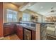 A wet bar with granite countertop, wood cabinets, and a beverage refrigerator for added convenience at 27316 N Covered Wagon Rd, Phoenix, AZ 85085