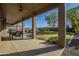 View of the backyard and pool from the covered patio area with seating and ceiling fans at 27316 N Covered Wagon Rd, Phoenix, AZ 85085
