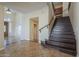 Welcoming entryway with beautiful wood staircase and tiled floors leading into the home at 27316 N Covered Wagon Rd, Phoenix, AZ 85085