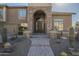 A beautiful home exterior with a stone arched entry, desert landscaping, and a charming front yard at 27316 N Covered Wagon Rd, Phoenix, AZ 85085