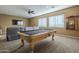 Entertaining game room with a pool table, comfortable sofa, and large windows for natural light at 27316 N Covered Wagon Rd, Phoenix, AZ 85085