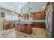 Gourmet kitchen features stainless steel appliances, granite countertops, custom cabinetry, and central island at 27316 N Covered Wagon Rd, Phoenix, AZ 85085