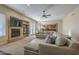 Inviting living space with a fireplace, TV, comfortable sectional sofa, and an open view of the kitchen at 27316 N Covered Wagon Rd, Phoenix, AZ 85085