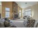 This living room features a stone fireplace, neutral tones, and large windows for natural light at 27316 N Covered Wagon Rd, Phoenix, AZ 85085