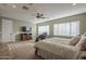 Bright primary bedroom with a ceiling fan, TV, and large windows at 27316 N Covered Wagon Rd, Phoenix, AZ 85085