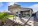 Cozy backyard patio with an umbrella, lounge chairs, and landscaped yard with pavers at 3187 E Pineapple Rd, San Tan Valley, AZ 85143