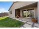 Inviting backyard patio with stone pavers, potted plants, and sliding glass doors at 3187 E Pineapple Rd, San Tan Valley, AZ 85143
