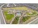 Aerial view of a vibrant community park with playgrounds, a pool, sports courts, picnic areas, and lush green spaces at 3187 E Pineapple Rd, San Tan Valley, AZ 85143