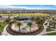 Fantastic aerial view of a community pool featuring palm trees, covered seating areas, and proximity to the neighborhood park at 3187 E Pineapple Rd, San Tan Valley, AZ 85143