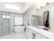 Bright main bathroom with a glass shower, standalone soaking tub, and marble countertops at 3206 W Knudsen Dr, Phoenix, AZ 85027