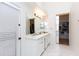 Clean, bright main bathroom with double sinks, white cabinets, and a view into the closet at 3206 W Knudsen Dr, Phoenix, AZ 85027