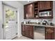 Features a mini fridge, granite countertops, wooden cabinetry, sink and natural lighting at 4030 N 54Th Pl, Phoenix, AZ 85018