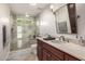 Bathroom with walk-in shower, marble countertops, wood cabinets and modern fixtures at 4030 N 54Th Pl, Phoenix, AZ 85018