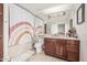 Bathroom featuring a large mirror, cabinet, rainbow shower curtain, and beige tiled floors, offering a functional space at 4030 N 54Th Pl, Phoenix, AZ 85018