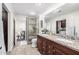Bathroom featuring a modern shower, granite countertop with double sinks, and access to the bedroom and laundry room at 4030 N 54Th Pl, Phoenix, AZ 85018