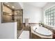 Bathroom featuring a glass shower, and a modern bathtub with a window, all in a well-lit, stylish space at 4030 N 54Th Pl, Phoenix, AZ 85018