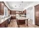 A spacious kitchen with dark wood cabinets, granite countertops, stainless steel appliances and a large center island at 4030 N 54Th Pl, Phoenix, AZ 85018