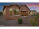 Twilight view of a lovely backyard with desert landscaping and comfortable outdoor seating at 42335 W Waterfall Way, Maricopa, AZ 85138