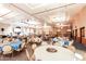 Spacious banquet hall featuring round tables with blue and white tablecloths, stage, and ample lighting at 42335 W Waterfall Way, Maricopa, AZ 85138