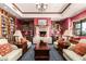 Charming library with a fireplace, comfortable seating, and extensive bookshelves for a cozy reading space at 42335 W Waterfall Way, Maricopa, AZ 85138