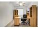 Bright office with a desk, leather chair, built-in shelving, and a large window at 42335 W Waterfall Way, Maricopa, AZ 85138